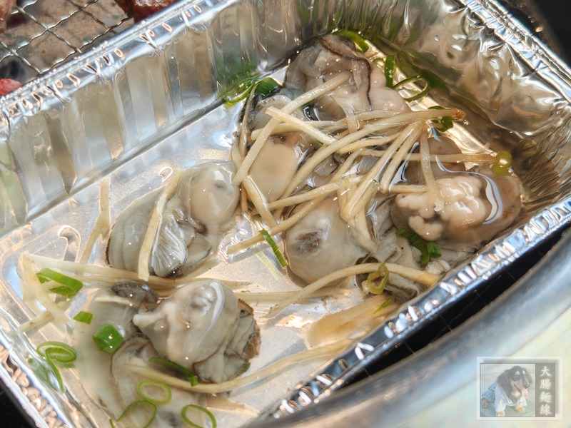 鋁箔盒中的鮮蚵與蔥花配料