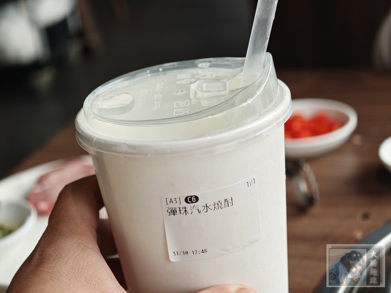 杯身貼有彈珠汽水燒酎標籤的手搖杯飲品